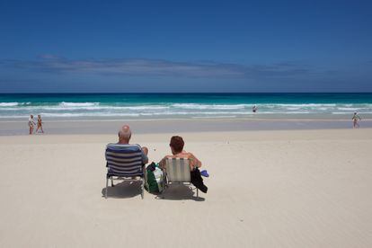 Varias personas en la playa de Corralejo, en Fuerteventura.