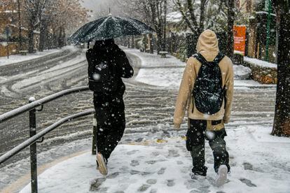 Varias personas en las calles nevadas de la región mallorquina de Valldemossa, en la sierra de Tramuntana. 
