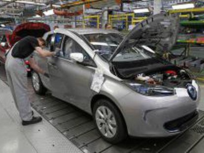 An employee works on a Renault Zoe electric car on the production line at the Renault automobile factory in Flins, west of Paris, May 28, 2013.   REUTERS/Benoit Tessier   (FRANCE - Tags: TRANSPORT BUSINESS INDUSTRIAL)