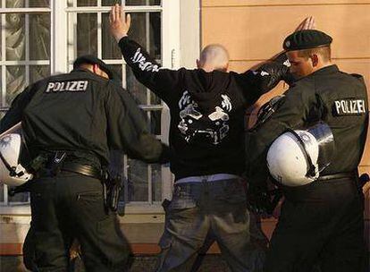 Dos policías detenienen a uno de un hincha alemán