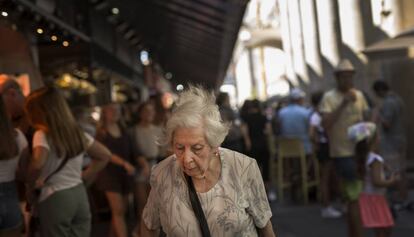 Una anciana passeja pel Mercat de la Boquería de Barcelona