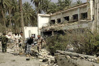 Las fuerzas de seguridad inspeccionan una comisaría en Baquba tras la explosión de un coche bomba.