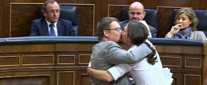 El líder de Podemos, Pablo Iglesias, y el de En Comú Podem, Xavier Domènech, se besan en el Congreso en marzo de 2016.