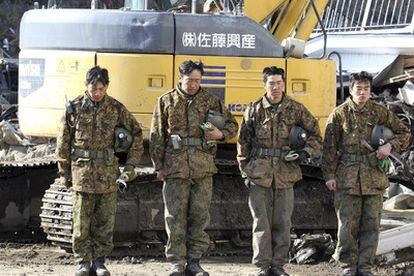 Soldados japoneses aguardan el momento de silencio en honor a las víctimas del terremoto y tsunami, en la ciudad de Miyako.
