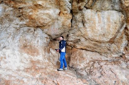 Un arqueólogo observa las pinturas rupestres de la gruta de Los Machos.