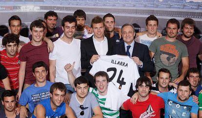 Asier Illarramendi y Florentino P&eacute;rez sostienen la nueva camiseta del centrocampista vasco, rodeados por su cuadrilla.