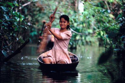Una joven navega en una canoa por el río Amazonas, en la región de Loreto (Perú).