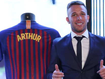 Arthur posa en el Camp Nou junto a la camiseta del Barça.