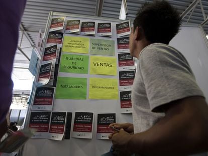 Un solicitante de trabajo ve un tablero de ofertas laborales durante una feria de empleos en Ciudad de México.
