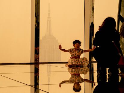 Turistas en el mirador Summit One Vanderbilt se toman fotos con el edificio Empire State, el 7 de junio de 2023 en Nueva York.