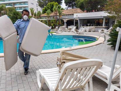 Un trabajador acondicionando la piscina en un hotel de Riu en Palma de Mallorca.