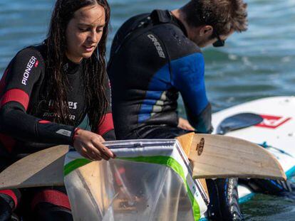 Voluntaris reullen plàstics a la platja de Barcelona per al projecte Surfing for Science.