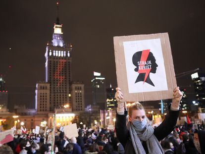 Una mujer con un cartel de la organización feminista que lidera las protestas contra el Gobierno de Polonia el viernes en una multitudinaria manifestación en Varsovia.