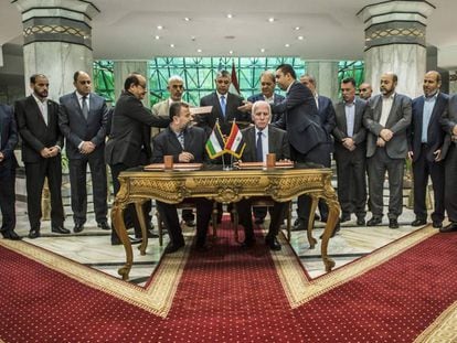 Azzam al-Ahmad (en la mesa, a la derecha), representante de Fatah, y  Salah al-Aruri  (izquierda), l&iacute;der de Hamas, firman la reconciliaci&oacute;n en el Cairo, este jueves