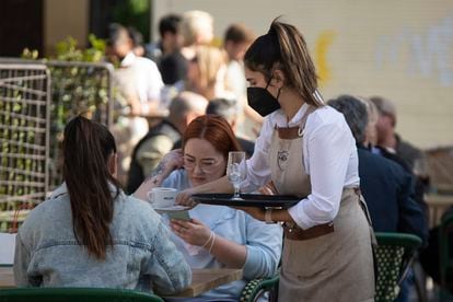 A waitress attends a terrace in the center of Seville in November.