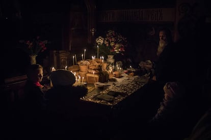 Varios niños observan una mesa llena de dulces ante la mirada de un monje en el monasterio.