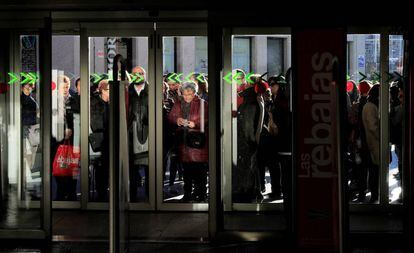 Un grupo de personas aguarda a la apertura de puertas de una tienda en Madrid.