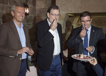 Mariano Rajoy; el vicepresidente de la Xunta, Alfonso Rueda, y el alcalde de A Cañiza (Pontevedra), Miguel Domínguez, degustan una tapa de jamón.