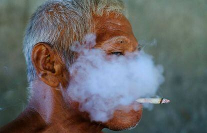 Un trabajador fuma un cigarrillo en una fábrica textil de Solo, en Indonesia.