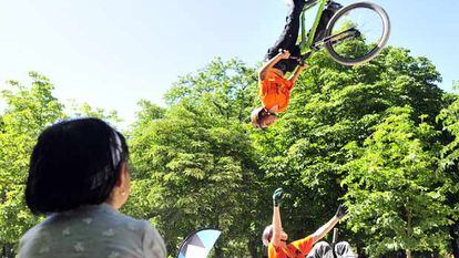 Jóvenes ciclistas hacen acrobacias en el Retiro durante la celebración del Día del Deporte.