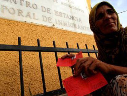 Una refugiada siria muestra su tarjeta de refugiada a las puertas del CETI de Melilla.