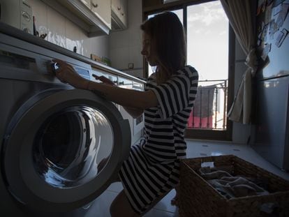 Una mujer pone una lavadora en su domicilio.