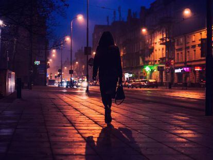 Una mujer camina por una calle, en una foto de archivo.