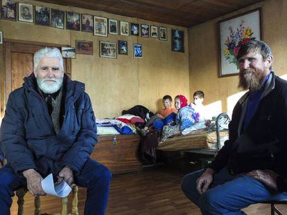 Fedor Kronikovski (a la izquierda) conversa con Ulián Murashov (derecha). Al fondo, los dos hijos de la familia, Agripina y Filaret, junto a otro niño.