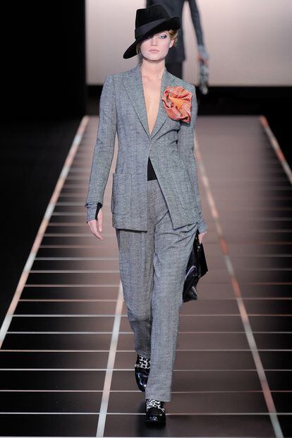 Giorgio Armani fiel a su estilo minimal nos propone este traje de raya diplomática que decora con una flor XXL en tonos naranjas. Un complemento que aporta un aire femenino a un look masculino.