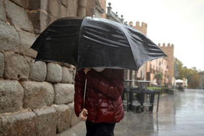 Una persona se protege de la lluvia este martes en Ávila.