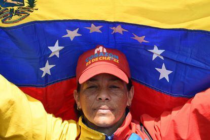 Una simpatizante del líder chavista exhibe una bandera nacional, durante una manifestación oficialista en Caracas. En su gorra se puede leer: "Mi corazón es de Chávez".