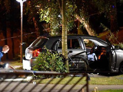 Un polic&iacute;a examina el coche contra el que un motorista ha disparado este domingo en Malmoe (Suecia). 