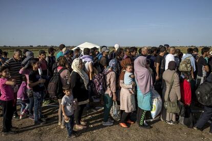 Los refugiados son escoltados por la policía hasta los autobuses que esperan junto al centro de recepción de inmigrantes en Roszke, Hungría.