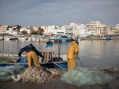 Dos pescadores faenan en el muelle de pescadores del puerto de L'Ampolla ( Tarragona).