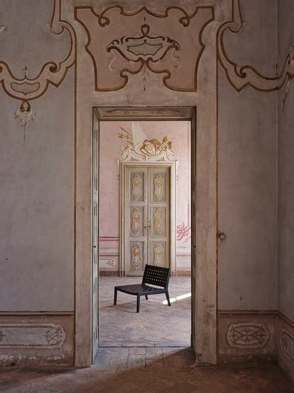 Una solitaria silla de madera y cuero creada para Zara Home por Vincent van Duysen en un decadente palacete barroco de Milán.