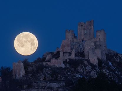 La luna llena aparece por detrás del castillo Rocca Calascio, en Italia, el 7 de marzo de 2023.