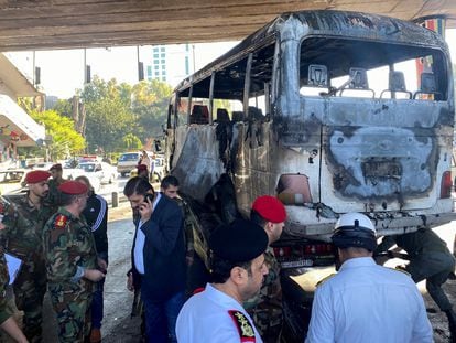 Miembros del Ejército sirio observan un autobús atacado con artefactos explosivos en Damasco, Siria, este miércoles.