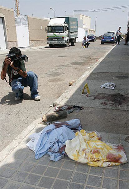 Un cámara fotografía restos de sangre en el lugar del suceso, la la barriada nijareña de Pueblo Blanco.