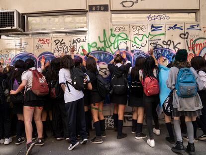Estudiantes frente de un establecimiento educativo durante una marcha para conmemorar el Día Internacional de la Mujer, en una calle de Valparaíso (Chile).
