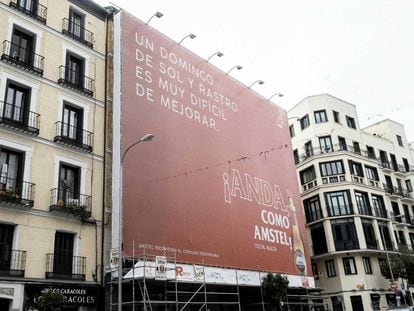 Una lona publicitaria tapa la fachada de un edificio en la Plaza del Cascorro, en La Latina