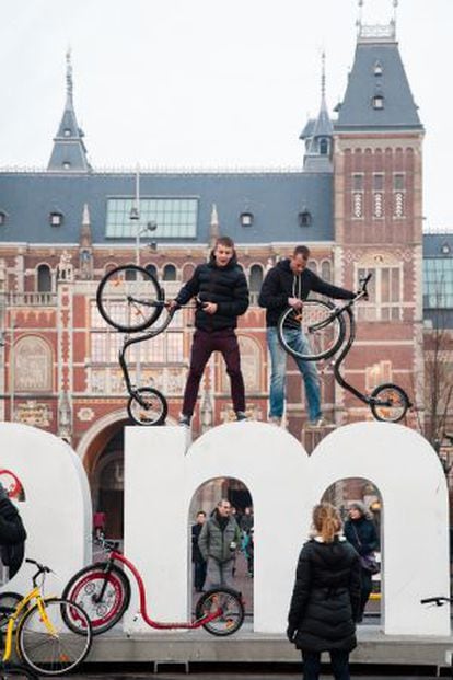J&oacute;venes con bicicletas sobre las ic&oacute;nicas letras que representan a la ciudad junto a la plaza de los museos. 