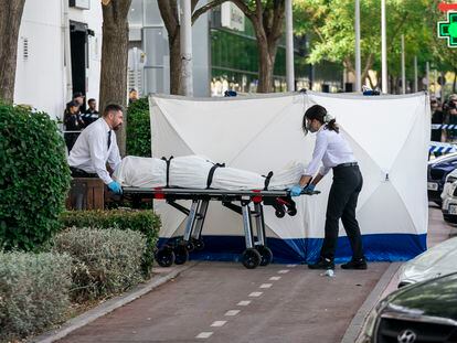 Dos trabajadores de la funeraria levantan el cadáver del hombre asesinado este lunes en una discoteca en Fuenlabrada (Madrid).