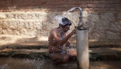 Un hombre se ducha en una fuente pública en los suburbios de Hyderabad (India).