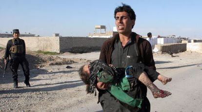 Un hombre traslada a una niña herida tras un atentado en Lashkar Gah, la capital de la provincia de Helmand, el pasado 16 de marzo.