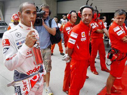 Los mecánicos de Ferrari observan a Lewis Hamilton tras la segunda sesión de entrenamientos libres celebrada ayer en Shangai.