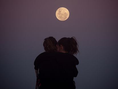 Una pareja se abraza debajo de la luna, en Florianópolis, Brasil.