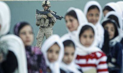 Unas niñas dan clases de español en la base Ruy González de Clavijo, en Qala-i-Naw (Afganistán), ante la vigilancia de un soldado.