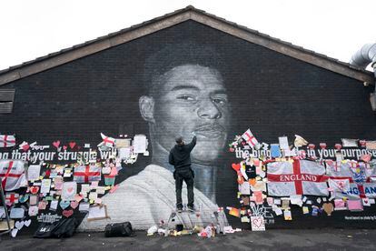 El grafitero Akse P19 repara el mural dedicado en Manchester al futbolista Marcus Rashford, después de que fuera dañado tras su fallo en los penaltis de la Eurocopa.