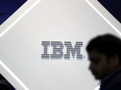 Una persona camina frente al logo de IBM en el Mobile World Congress de Barcelona.