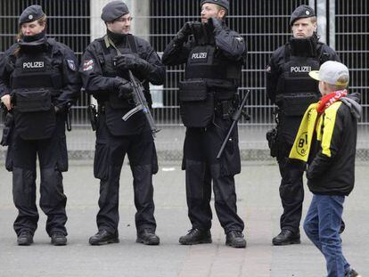 Un niño pasea frente a la policía.